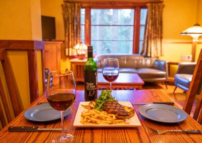 red wine with steak and fries in a cabin at Johnston Canyon Lodge and bungalows in Banff National Park